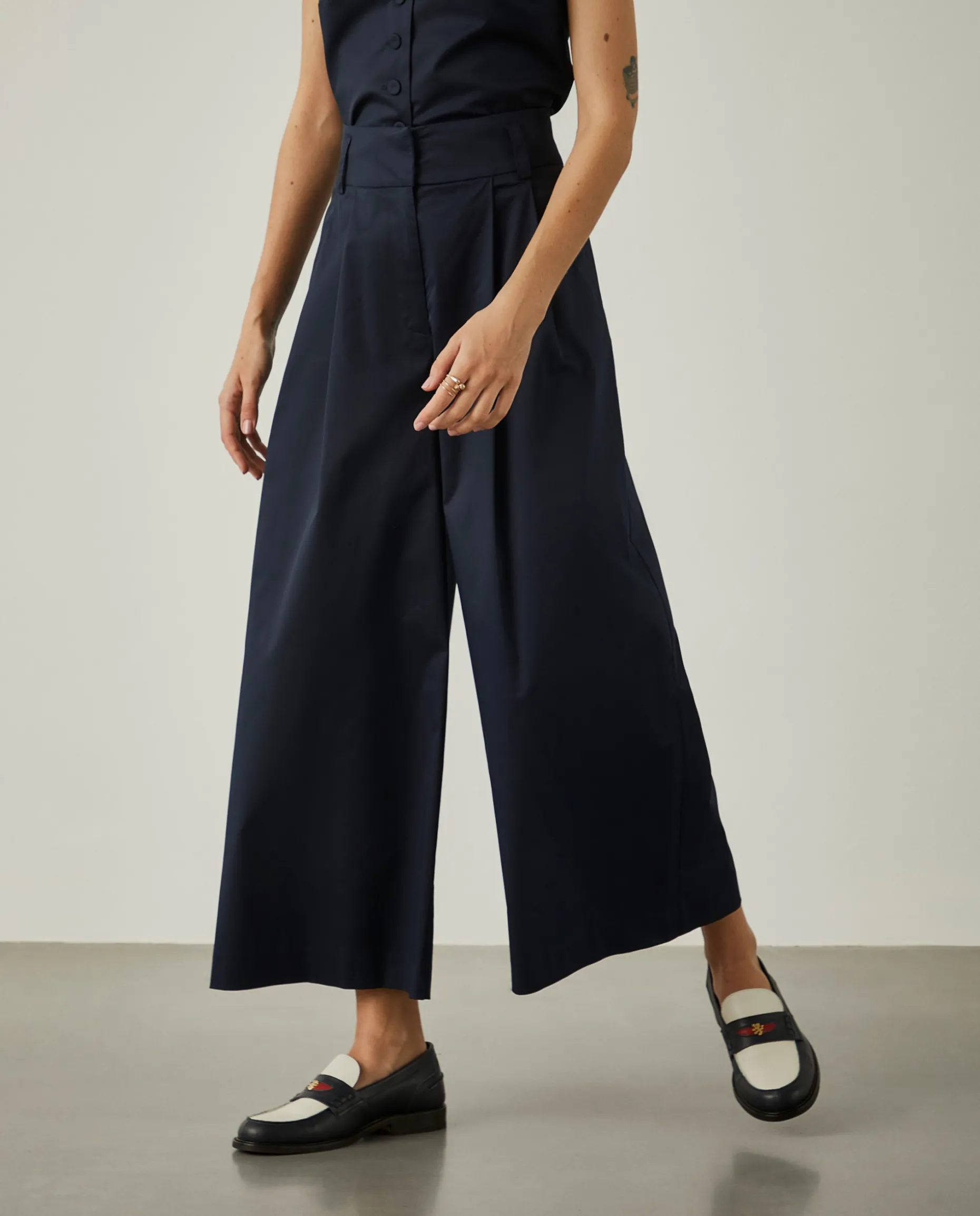 Calças de perna larga com pregas na frente