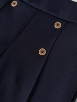 Calças em malha com botões e vincos