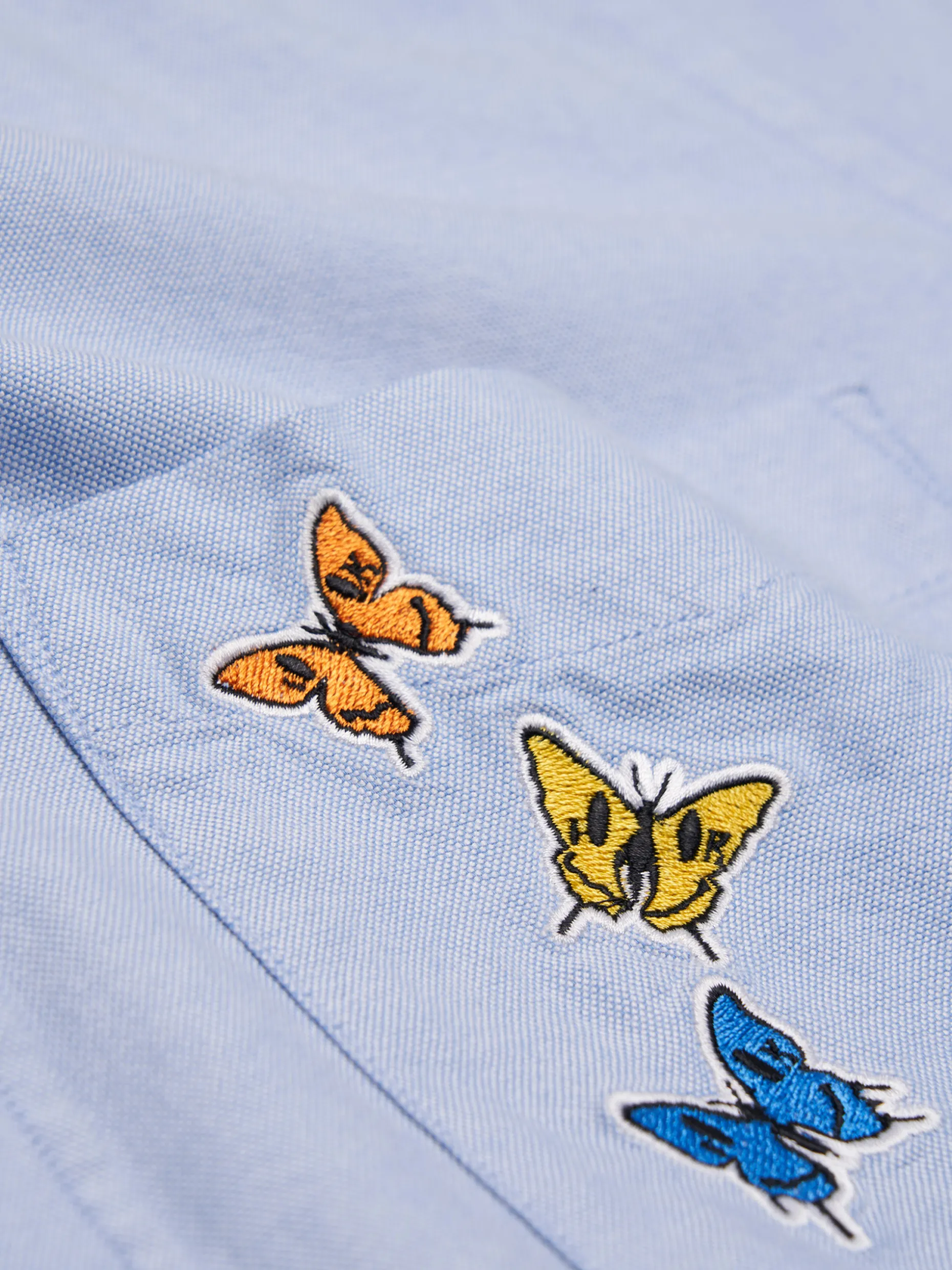 Camisa oxford com borboletas no bolso Lion x Killa