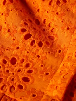 Vestido curto em bordado inglês e mangas abalonadas